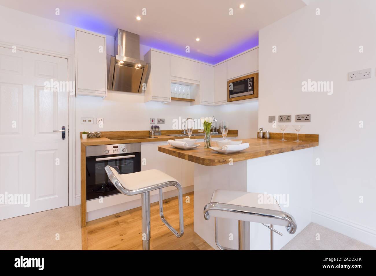 A modern kitchen with wooden counter tops cupboards breakfast bar and