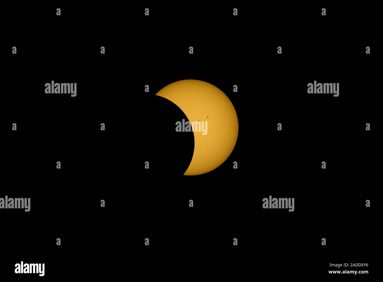 Total solar eclipse and sunspots. This partial phase of the eclipse is after totality, with a group (active region) of sunspots (AR2671) seen on the s Stock Photo