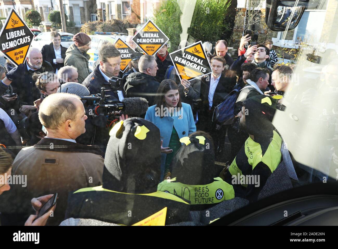Liberal Democrat leader Jo Swinson speaks to Extinction Rebellion protesters dressed as bees after they glued themselves to the party's battle bus during a visit to Knights Youth Centre in London, while on the General Election campaign trail. Stock Photo