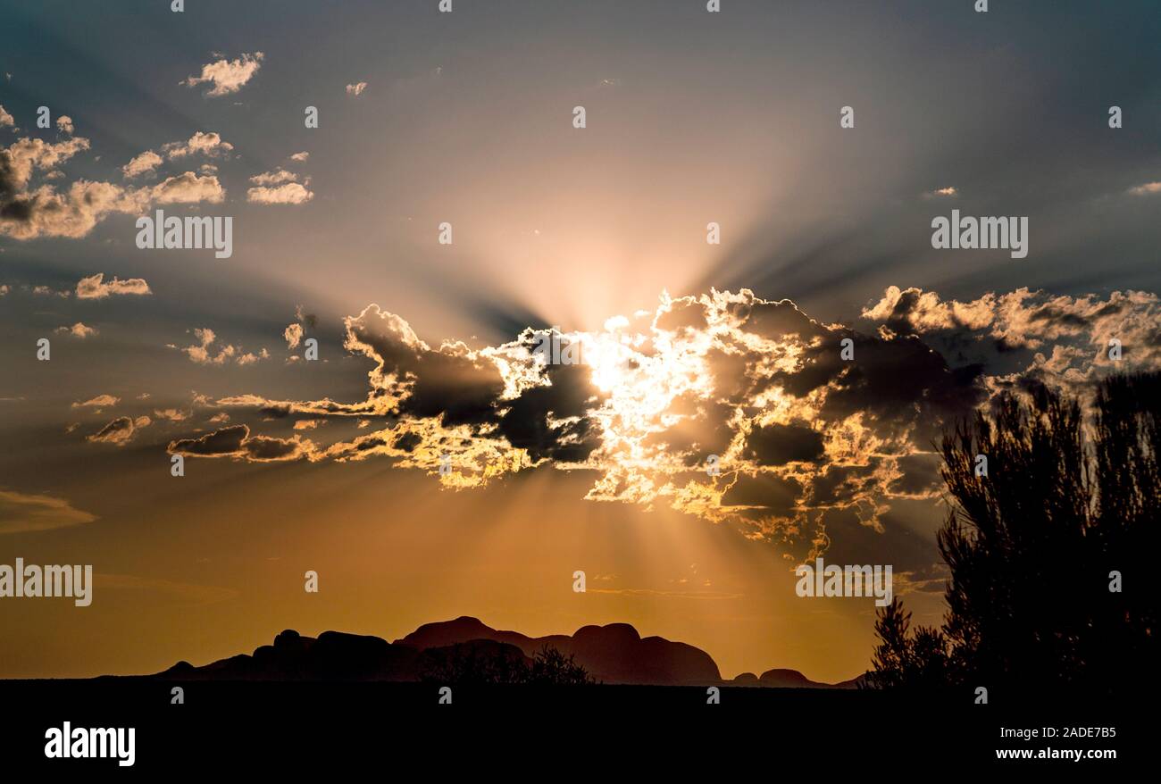 Sun and crepuscular rays shining through clouds near sunset over the ...