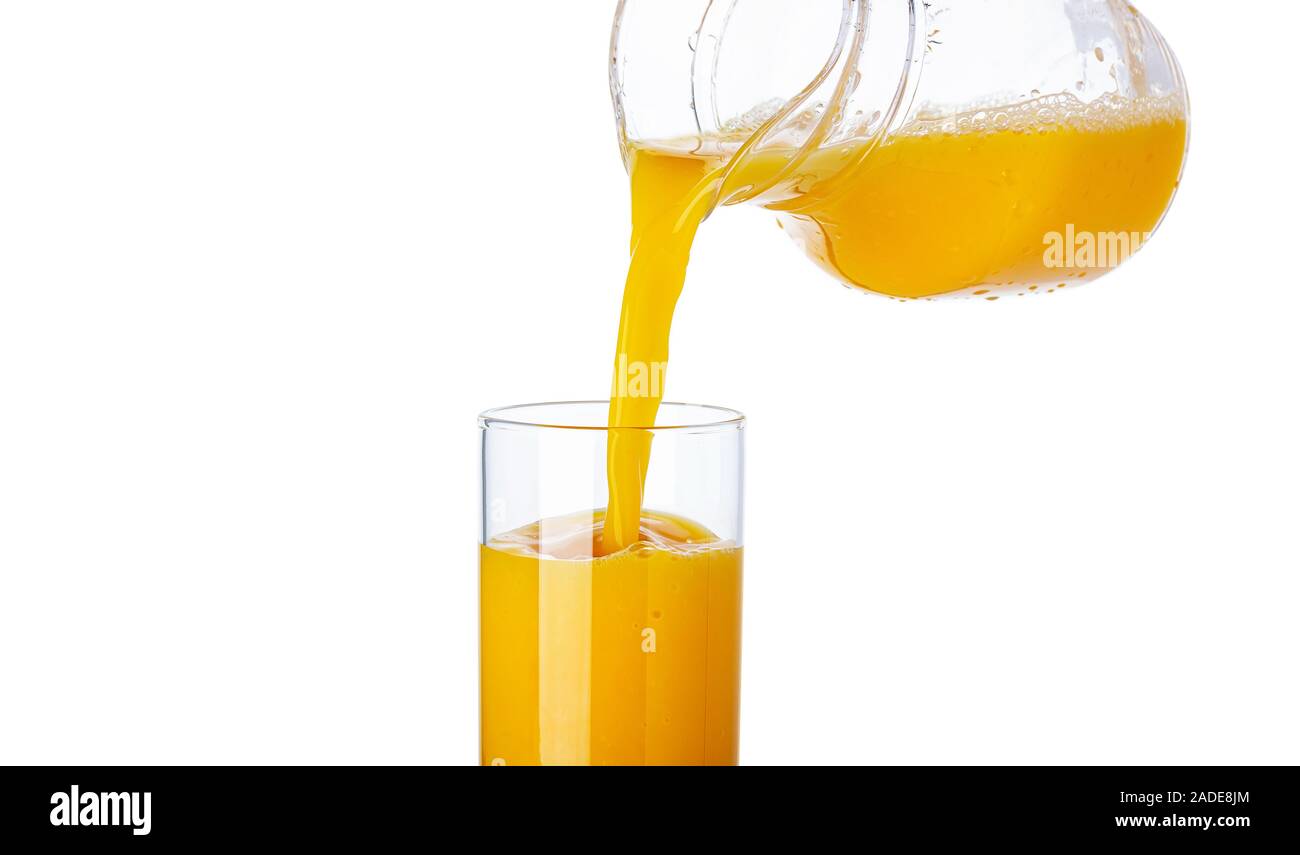 Orange juice pouring from pitcher into glass isolated on white