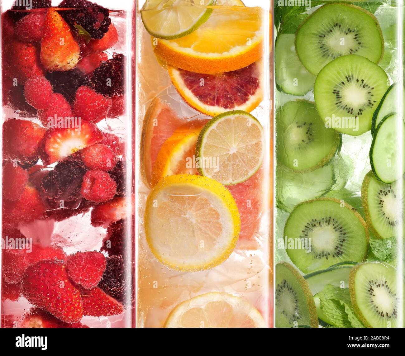 Whole and sliced fruit in water with ice. Stock Photo
