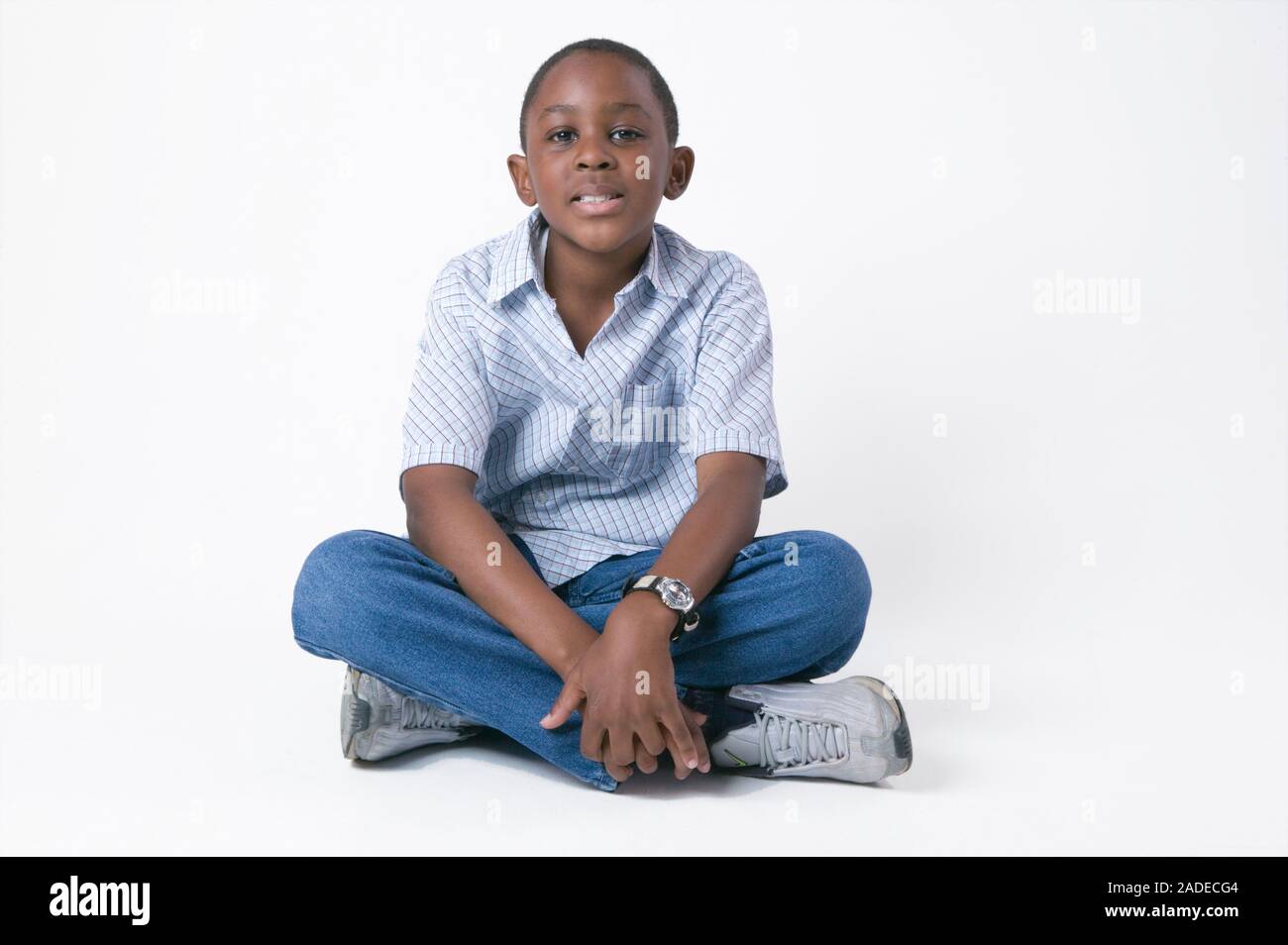 Young boy sitting on the floor crossed legged Stock Photo Alamy