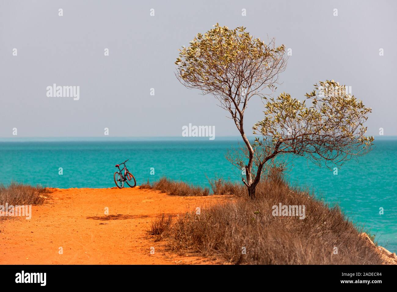 Bicycle standing at end of a red dirt track leading to the Indian ocean, Broome, West Kimberley