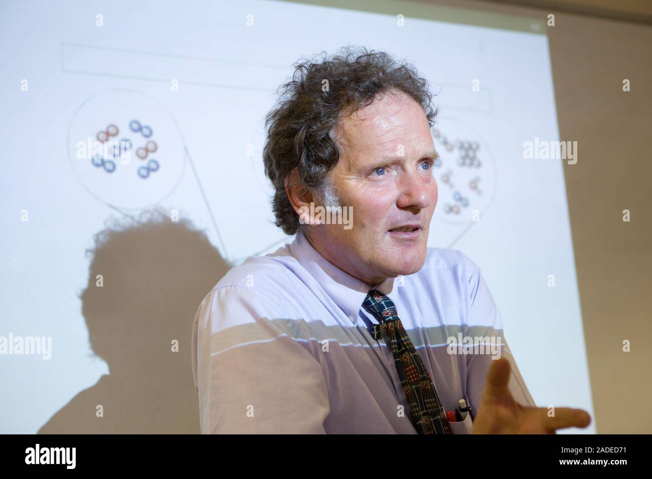 Secondary School teacher standing in front of a whiteboard explaining the background to car combustion and air quality, part of a core module of a sci Stock Photo