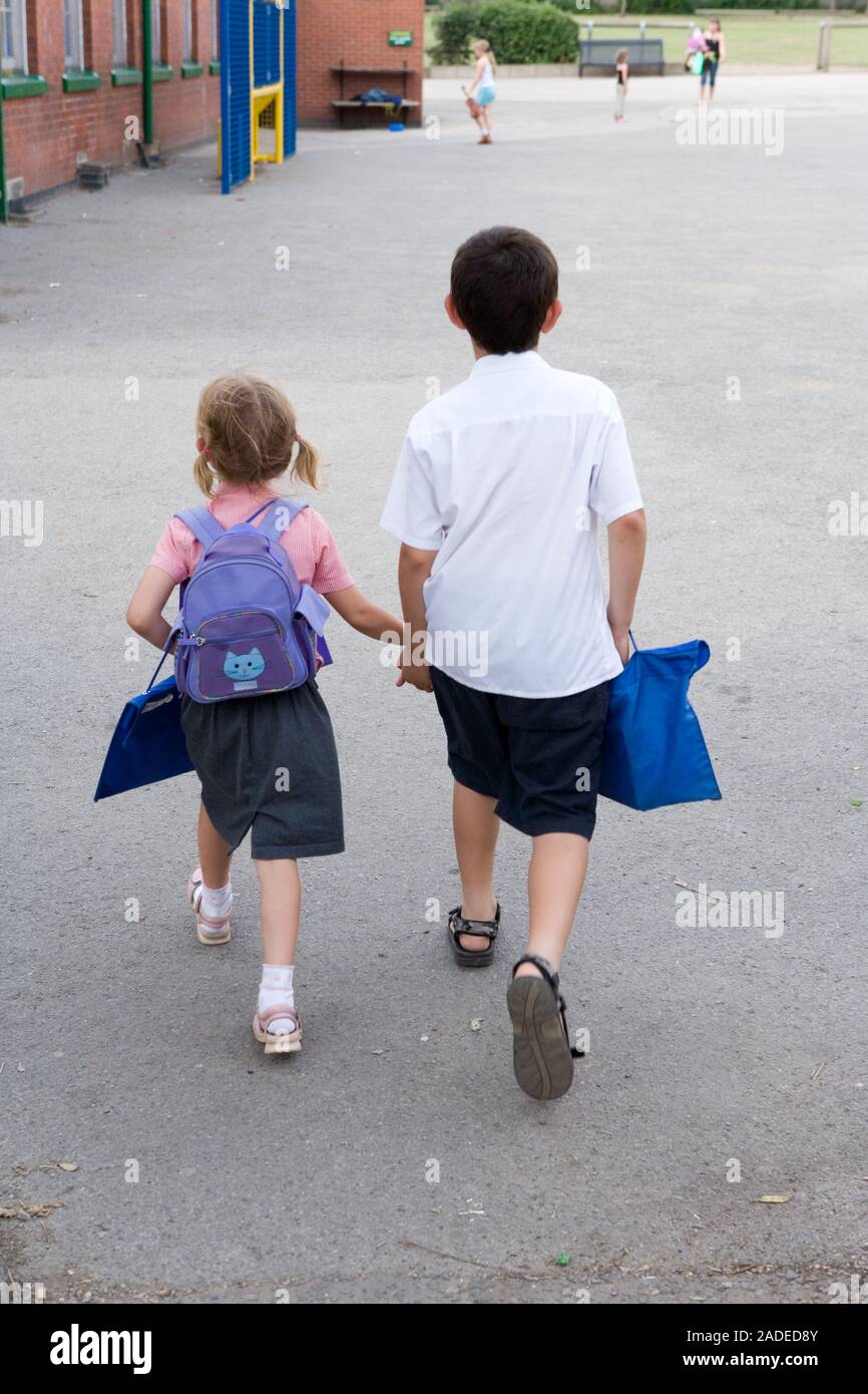 Brother and sister holding hands walking home from school Stock Photo ...