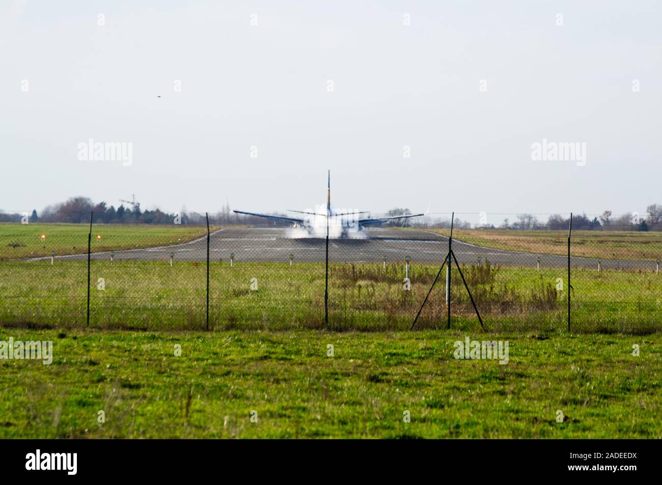 Ryanair Boeing 737-800 just touching down at Bergerac Airport with smoke coming of tyres / runway. Stock Photo