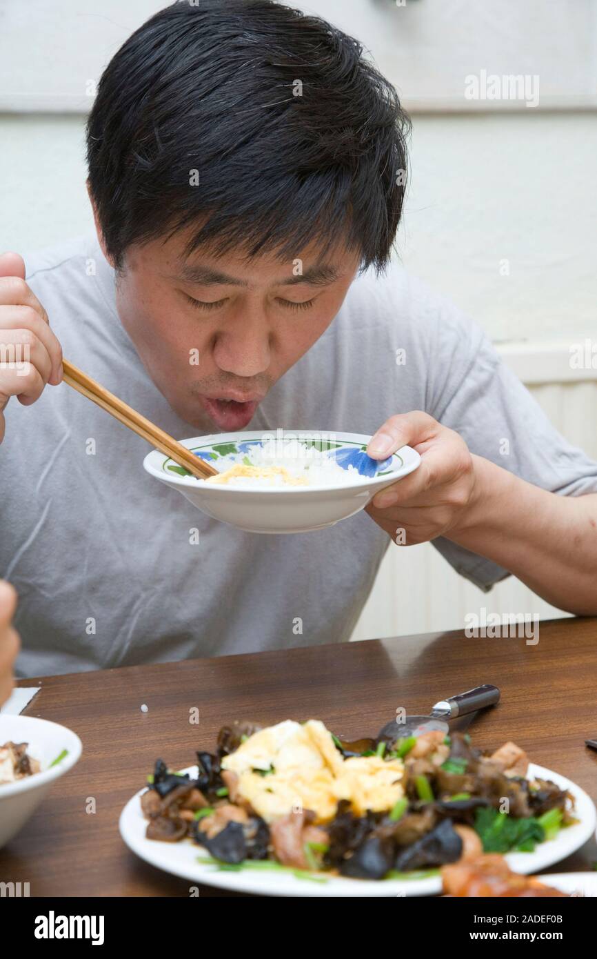 Man eating from a bowl of rice using chopsticks Stock Photo Alamy