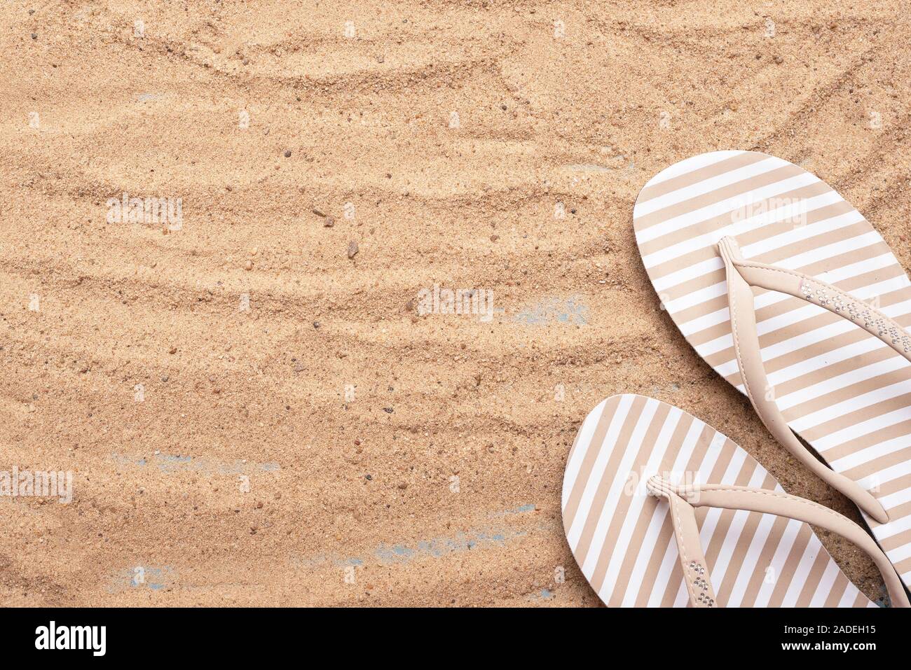 Flip flops on the sea beach sand on blue background copy space. Top ...