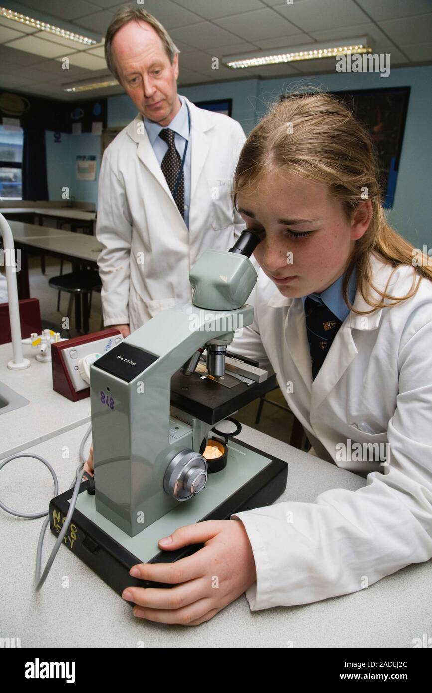 Secondary school student looking through a microscope in a science ...