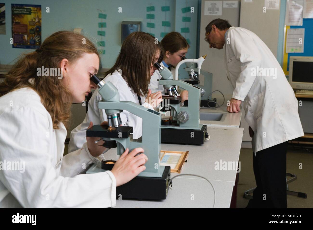 Secondary school students looking through a microscope in a science ...