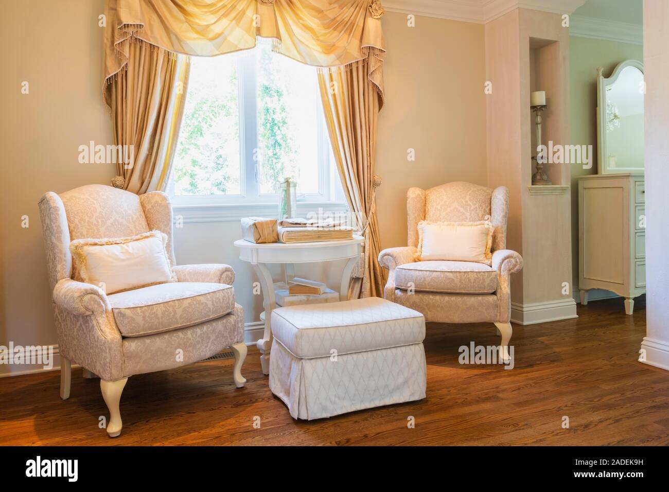 Upholstered armchairs, ottoman and table inside a luxurious residential home, Quebec, Canada Stock Photo