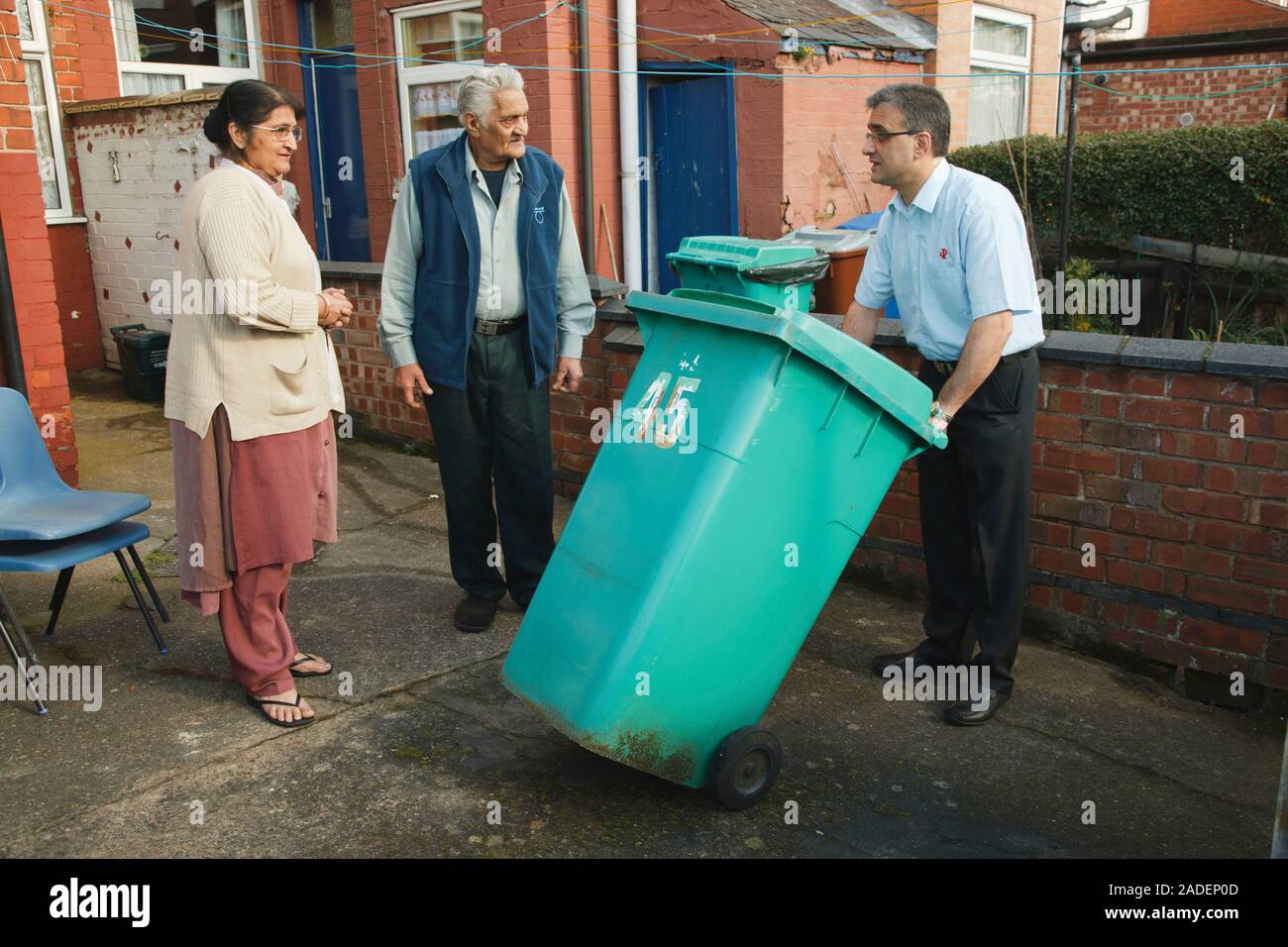 Son helping elderly south Asian parents by putting bin out Stock Photo Alamy