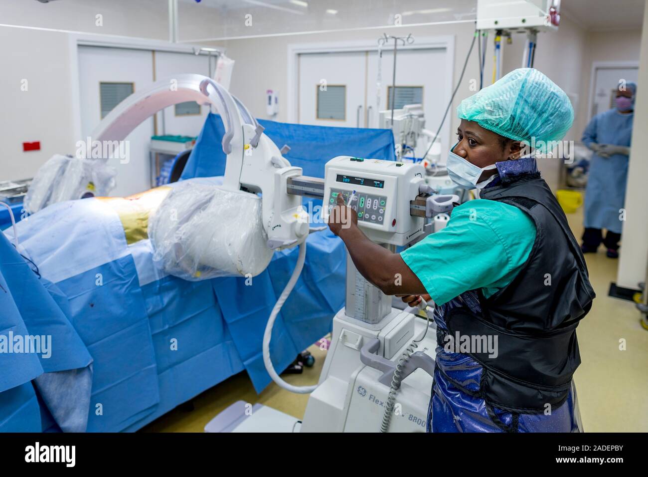 MODEL RELEASED. Spinal surgery radiography. Radiographer setting an X