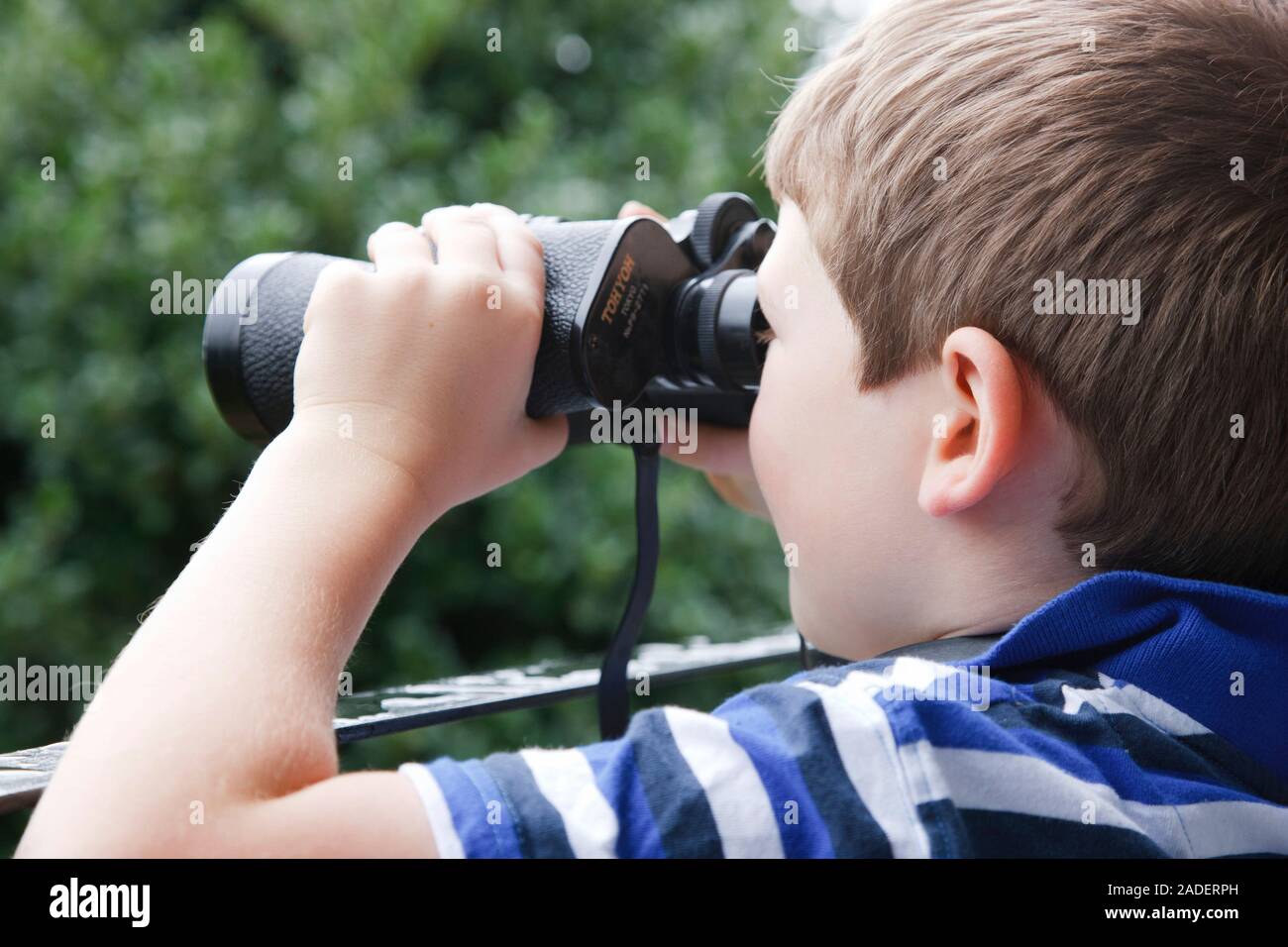 Boy looking through binoculars. Stock Photo