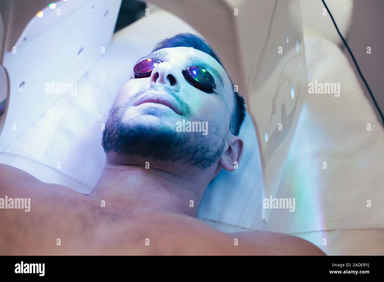 Face of bearded man lying in protective glasses Stock Photo