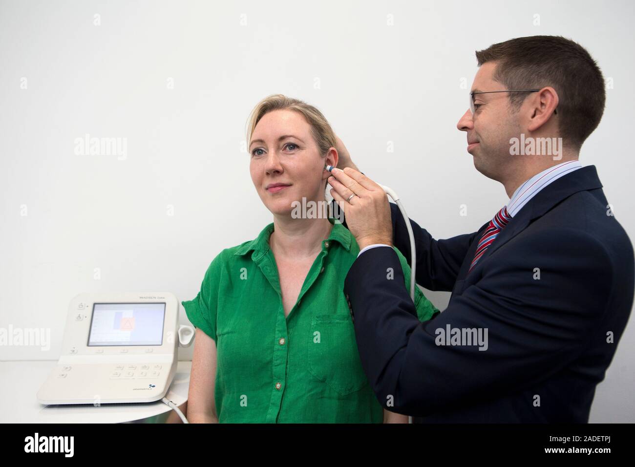 Audiologist carrying out a tympanometry assessment using a handheld tympanometer. This device is