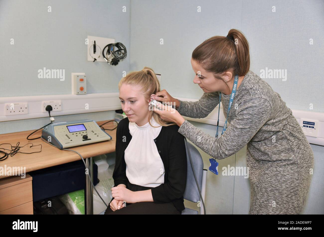Audiologist carrying out a tympanometry assessment using a handheld tympanometer. This device is
