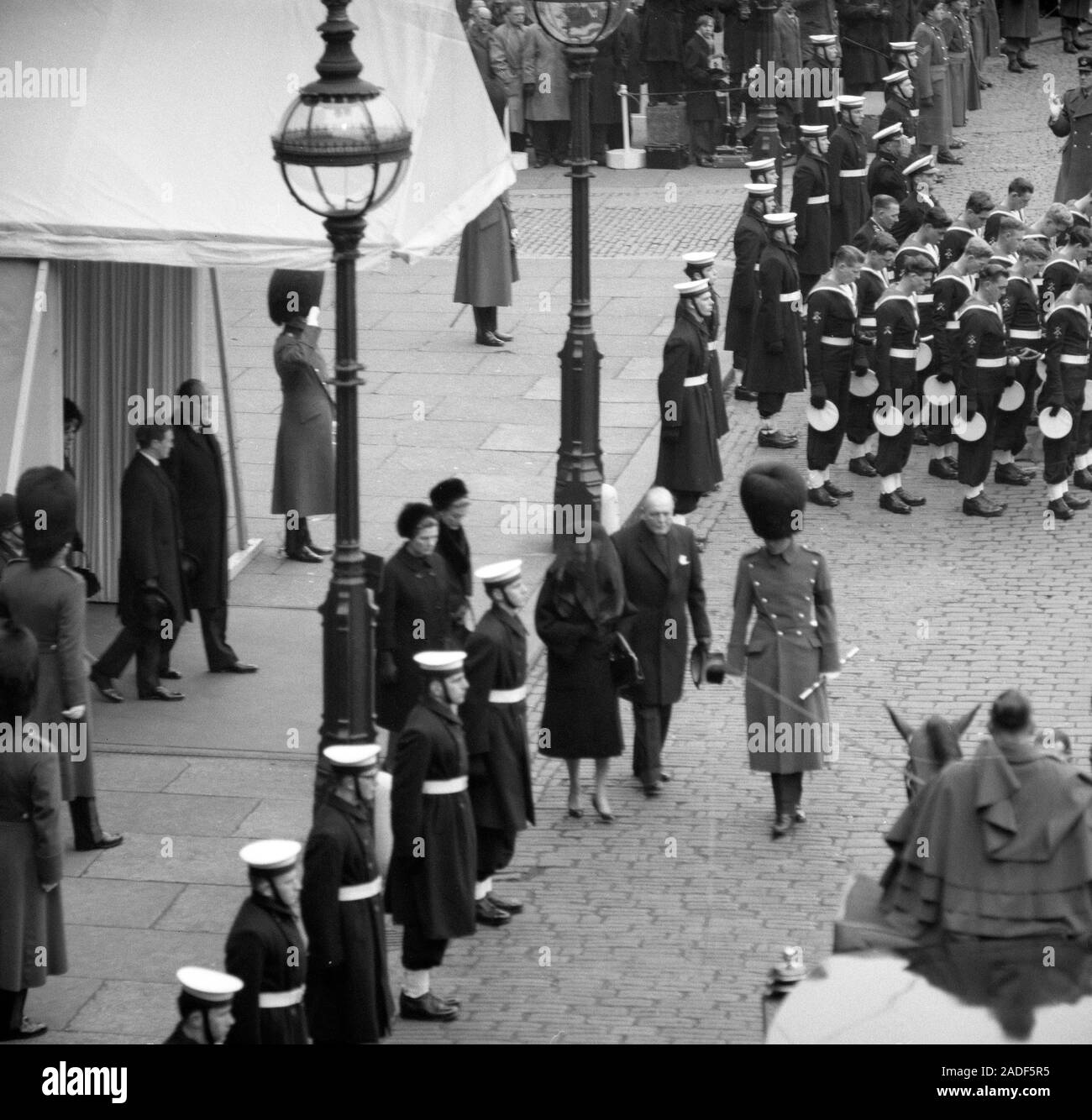 A veil covering her head, Lady Churchill and her son, Randolph Churchill, as they leave Westminster Hall for St Paul's Cathedral and the State Funeral of Sir Winston Churchill. Behind them are Sir Winston's daughters Mary Soames (left) and Sarah, Lady Audley (right). behind them walk Sir Winston's grandson, Winston Churchill (left) and Sir Winston's son-in-law, Christopher Soames. Stock Photo