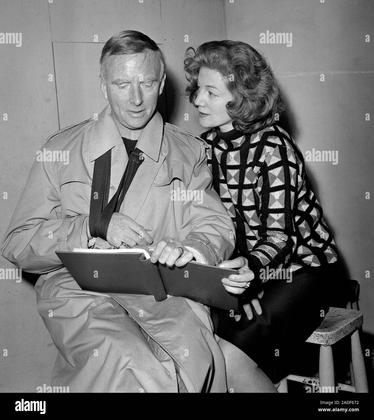 Sarah Churchill, actress daughter of Sir Winston Churchill, goes over the script with her husband, Lord Audley, author of the play 'From This Hill', during rehearsals in London. Lord Audley, recovering from a collarbone injury, has his arm in a sling. Stock Photo
