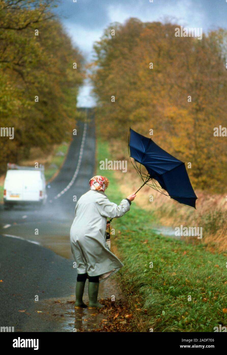 Storm. View of an elderly woman, walking along a country road, caught