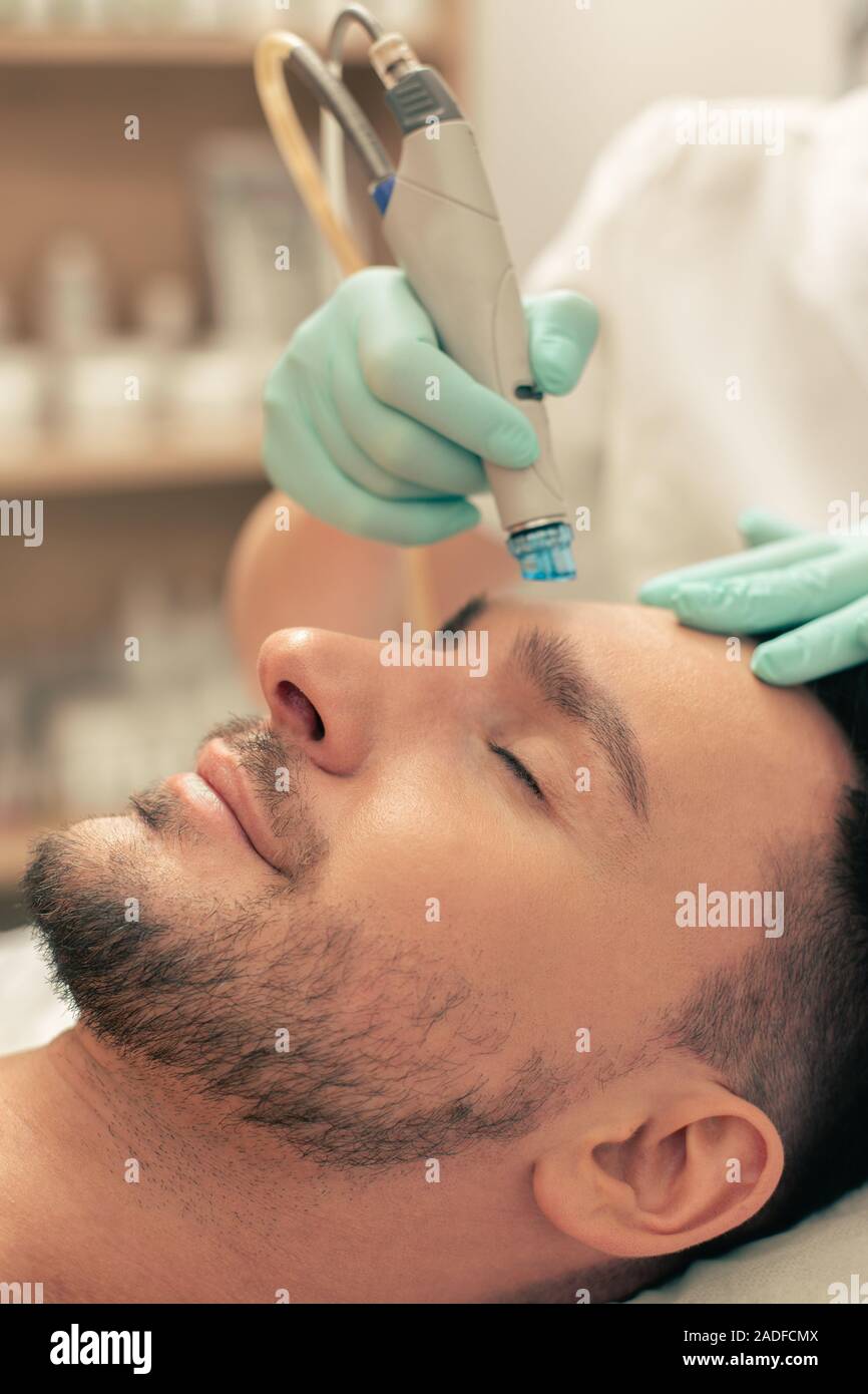 Modern nourishing tool on the forehead of the man Stock Photo