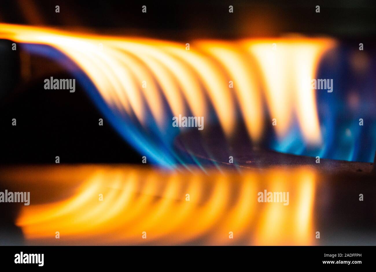A Macro Image of a Blurry Blue and Yellow Flames on Gas Stove Burner