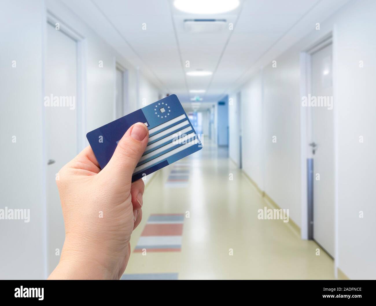 Selective focus on person hand holding blank European Health Insurance Card inside medical hospital. Seeking medical help in foreign country concept. Stock Photo