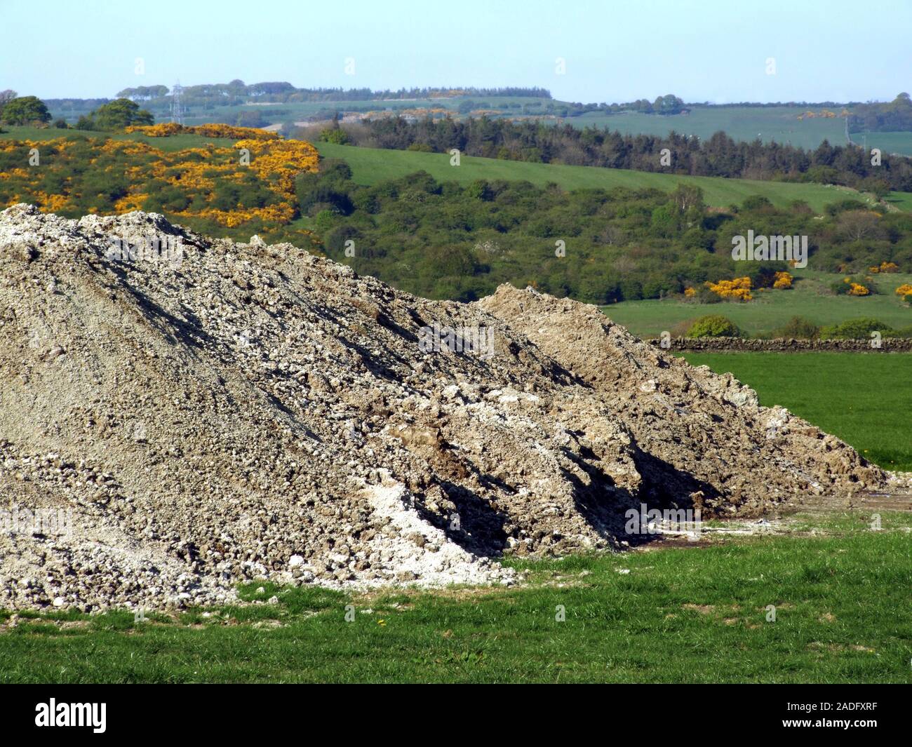 Human waste fertiliser. Pile of treated sewage sludge in a field