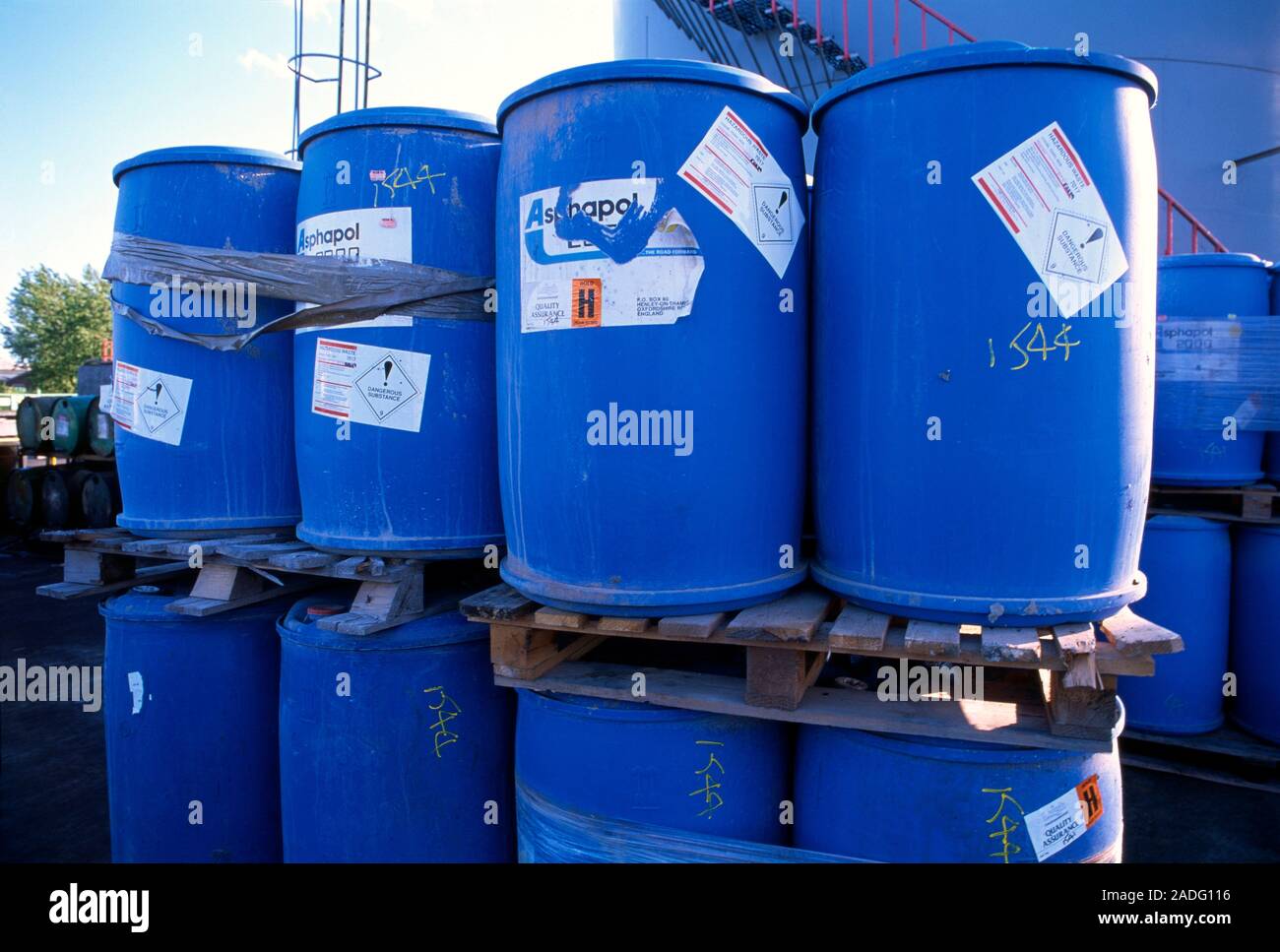 Drums of toxic waste at a disposal site. Each drum has a sign warning