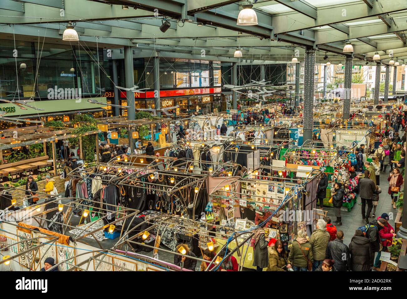 Old Spitalfields Market on a busy Sunday afternoon with stallholders and visitors enjoying the spectacle and trade London England UK Stock Photo