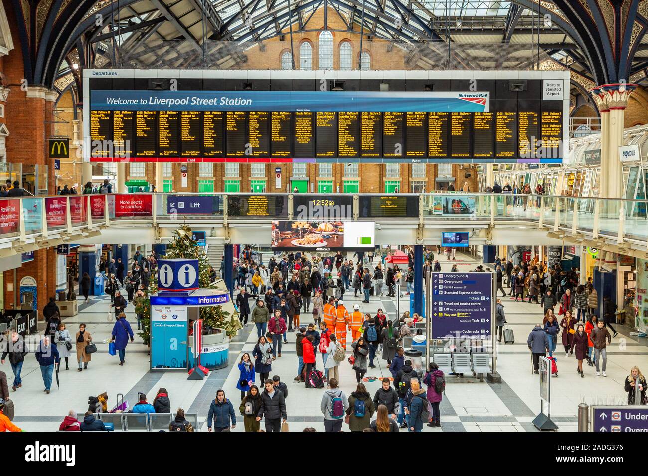 Liverpool Street Station concourse panorama showing commuters looking at the arrivals/departure board for train times, London England UK Stock Photo