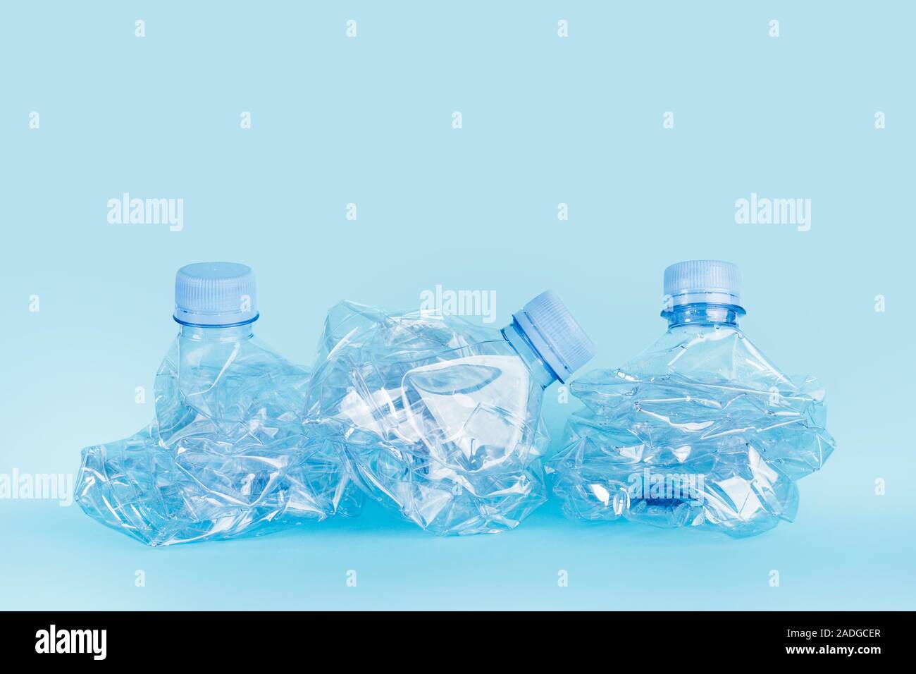 Crushed empty water bottles on a blue background Stock Photo