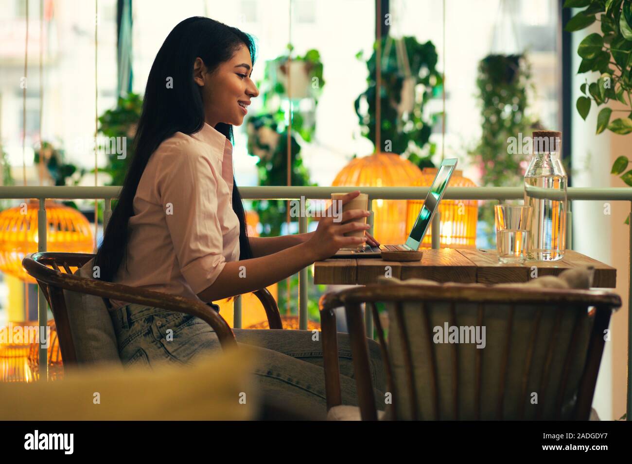 Confident young lady using laptop in the cafe Stock Photo