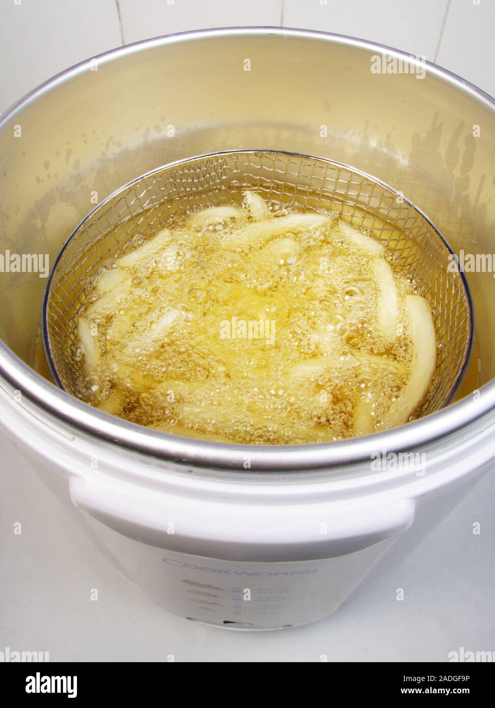 Chips in deep fat fryer. Deep fat fryer being used to cook potato chips