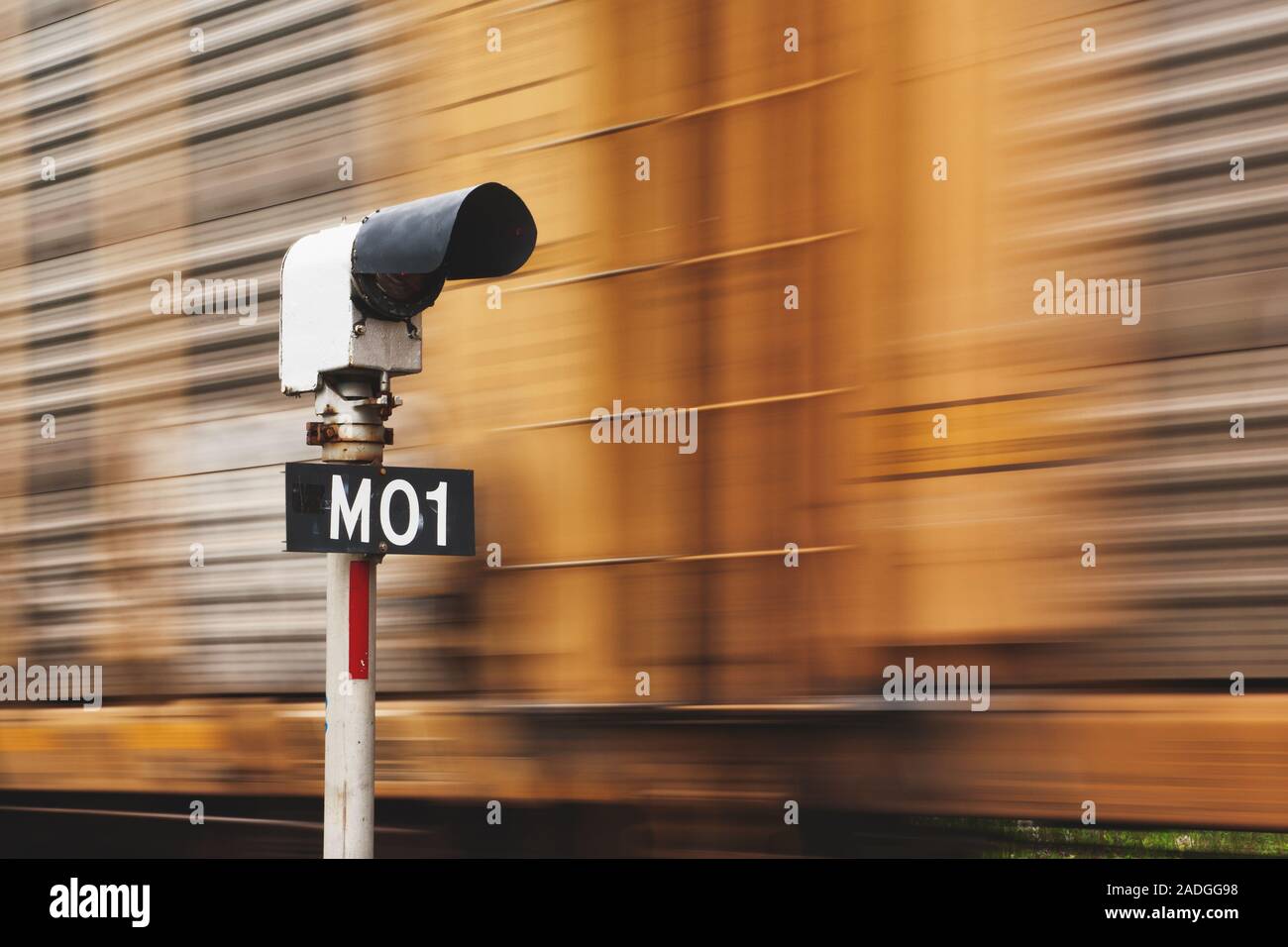 Railroad signal light post and passing train blur Stock Photo