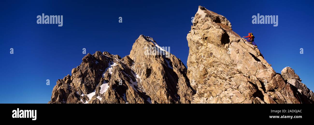 Low angle view of a man climbing up a mountain, Rockchuck Peak, Grand Teton National Park, Wyoming, USA Stock Photo