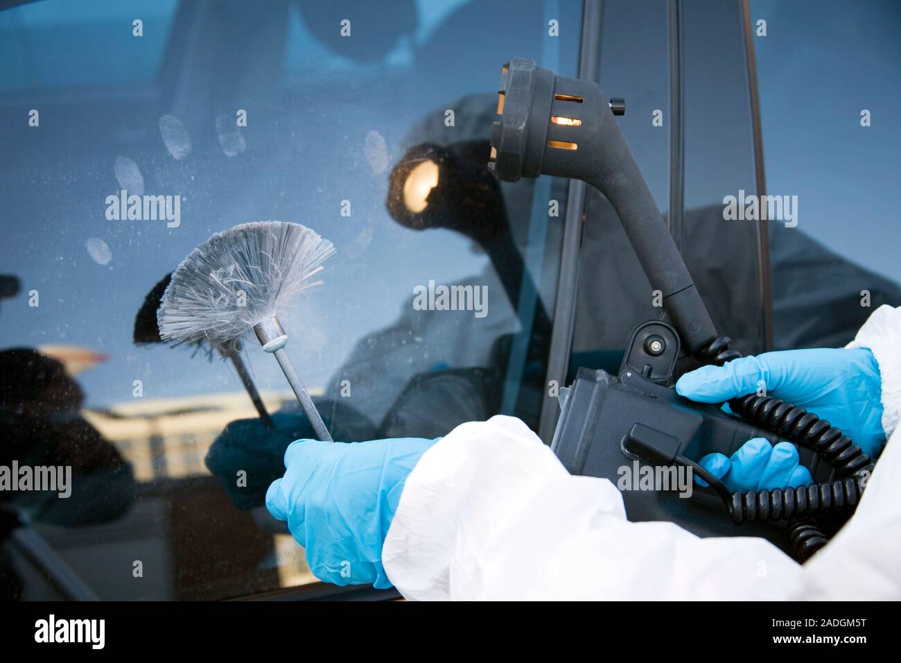 MODEL RELEASED. Dusting for fingerprints. Forensics officer collecting