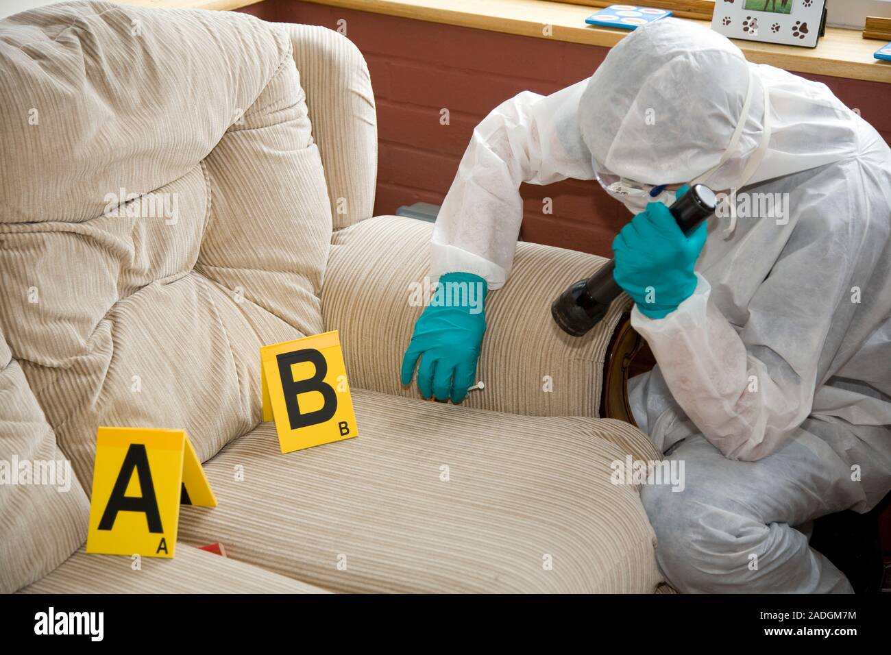 MODEL RELEASED. Collecting evidence. Forensic officer finding a syringe ...