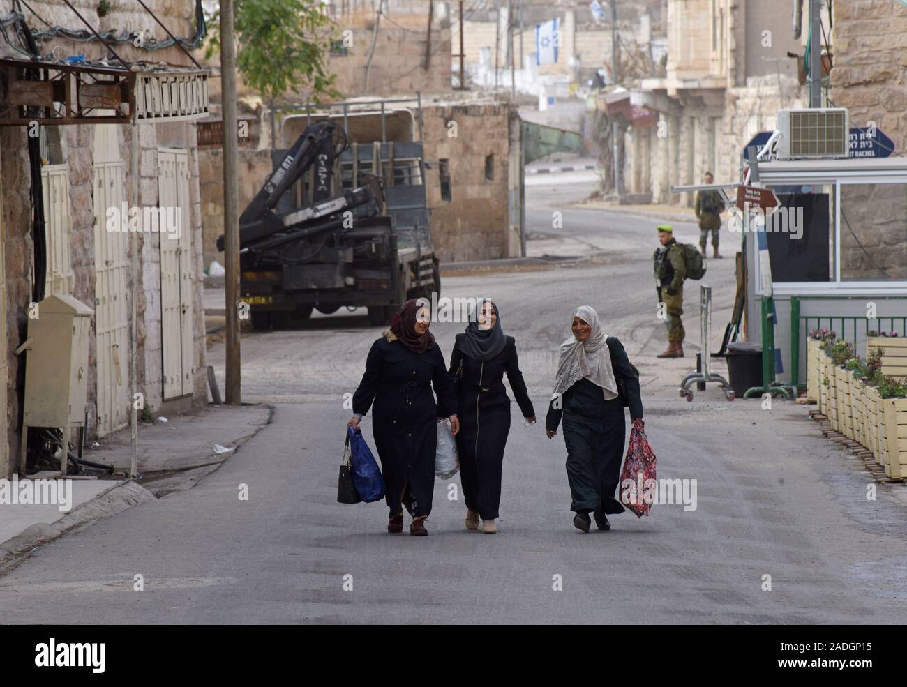 An Israeli soldier watches Palestinian women walk on Shuhada Street near The Tomb of the Patriarchs, or the Ibrahimi Mosque, in the divided city of Hebron, West Bank, on Wednesday, December 4, 2019. Israeli Defense Minister Naftali Bennett ordered officials to start planning a new Jewish settlement in the heart of Hebron, which Palestinian officials say is a result of U.S. President Donald Trump's decision to legitimize settlements.  Photo by Debbie Hill/UPI Stock Photo