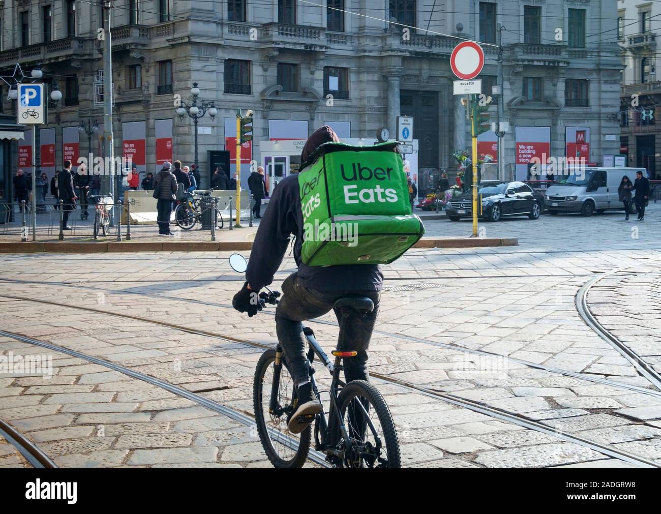 Uber Eats biker on the street in Milano running for a delivery, Italy Stock Photo