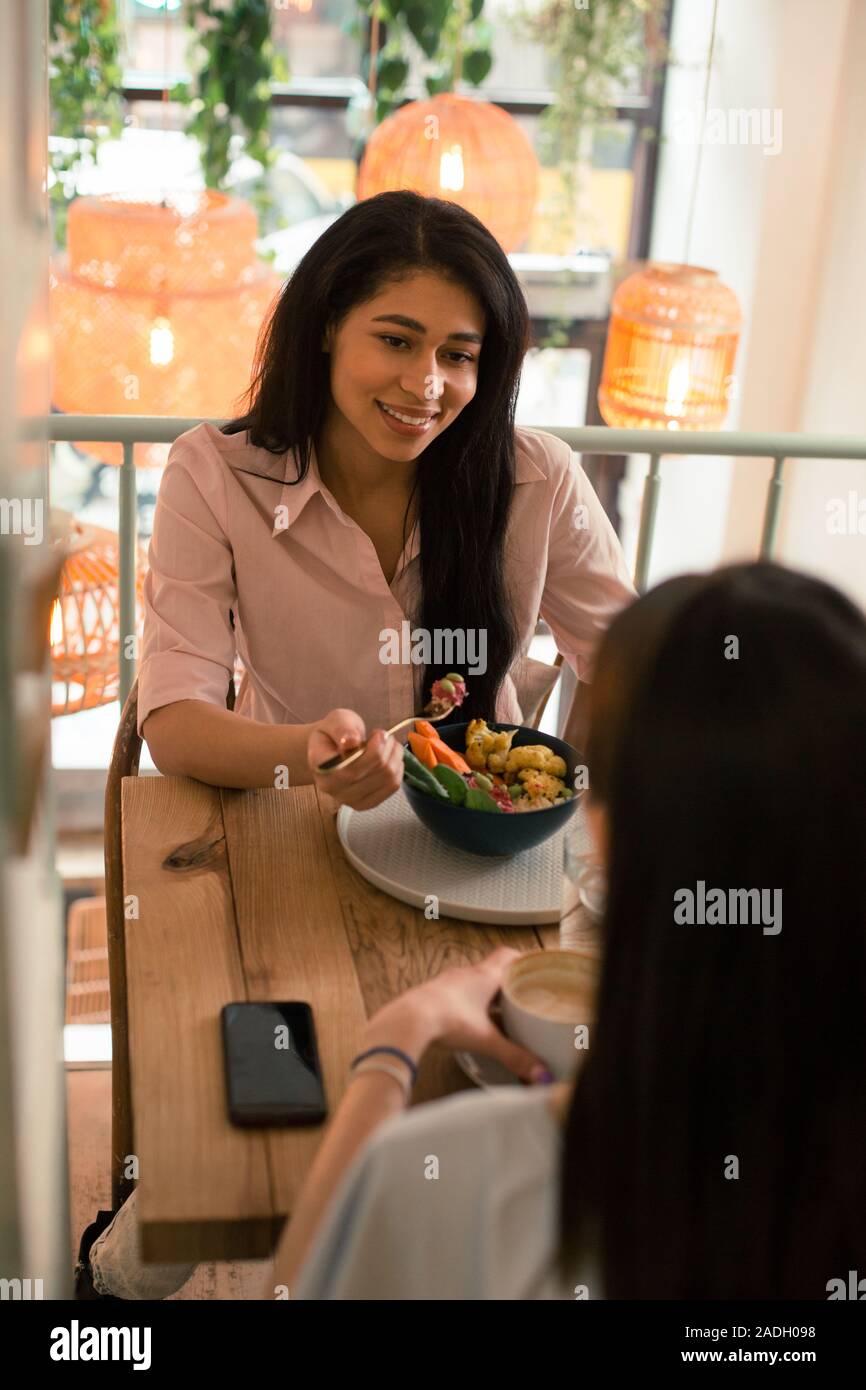 Two dark haired ladies having lunch in the cafe Stock Photo