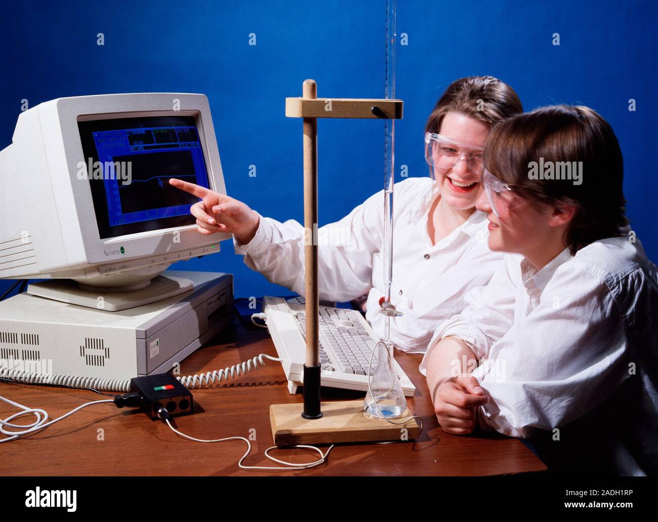 Chemistry experiment. Students performing a titration, which is monitored by a computer via a temperature probe (lower right). The computer makes it e Stock Photo