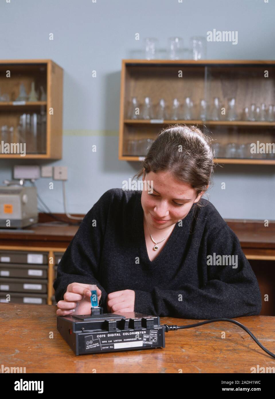 Student using a colorimeter to measure the hue of a sample of copper