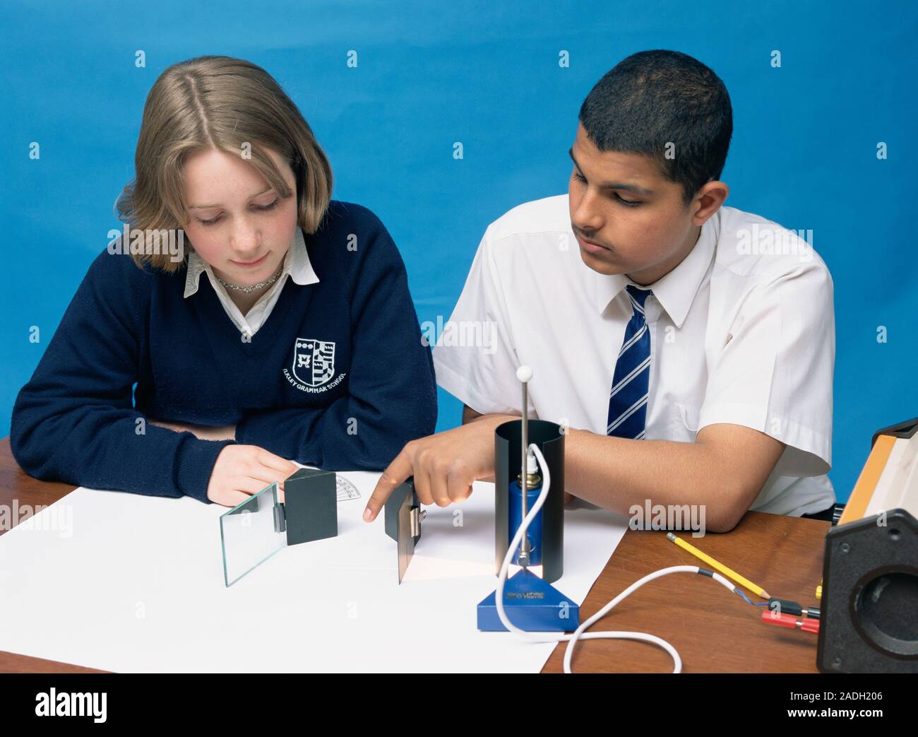 Physics lesson. Schoolchildren investigating the reflection of light ...