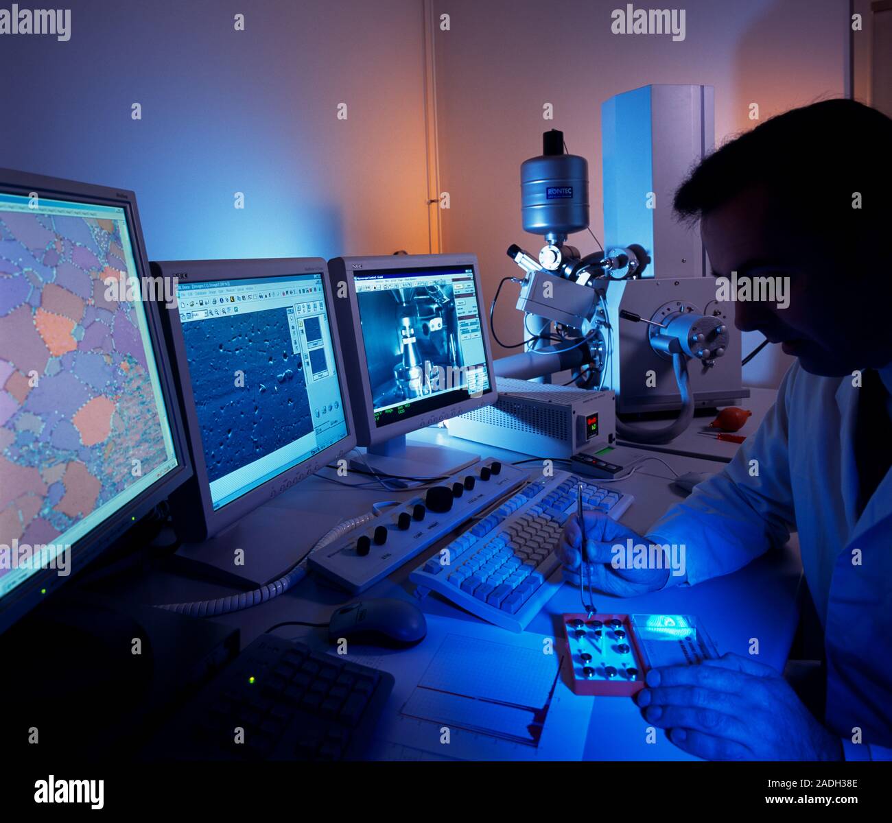 MODEL RELEASED. Scanning electron microscope. Scientist preparing a ...