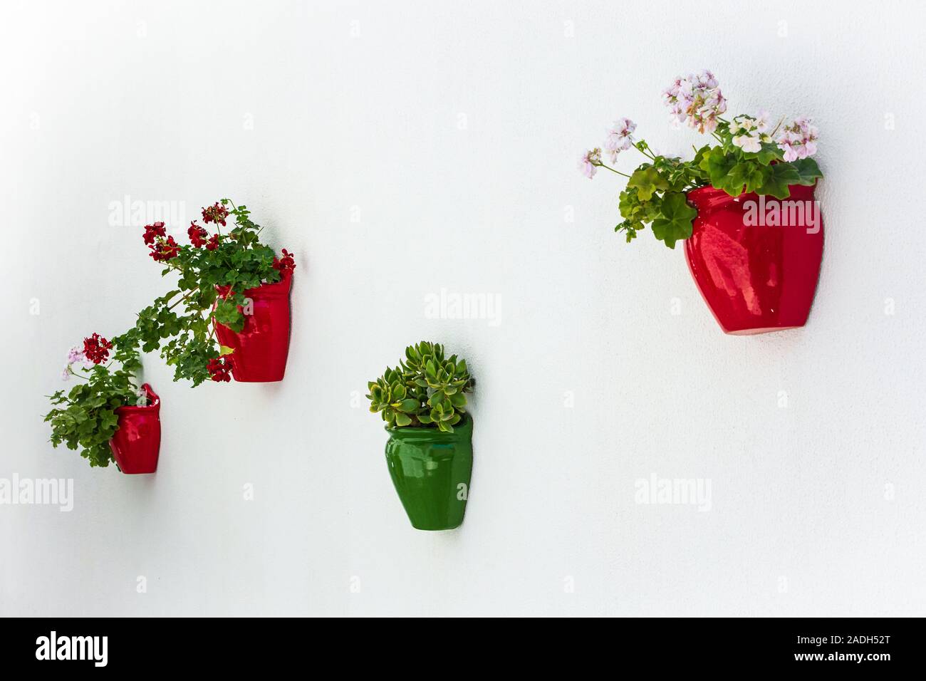 Colorful flower pots hanging on white wall. Alacati, Cesme, Izmir Stock