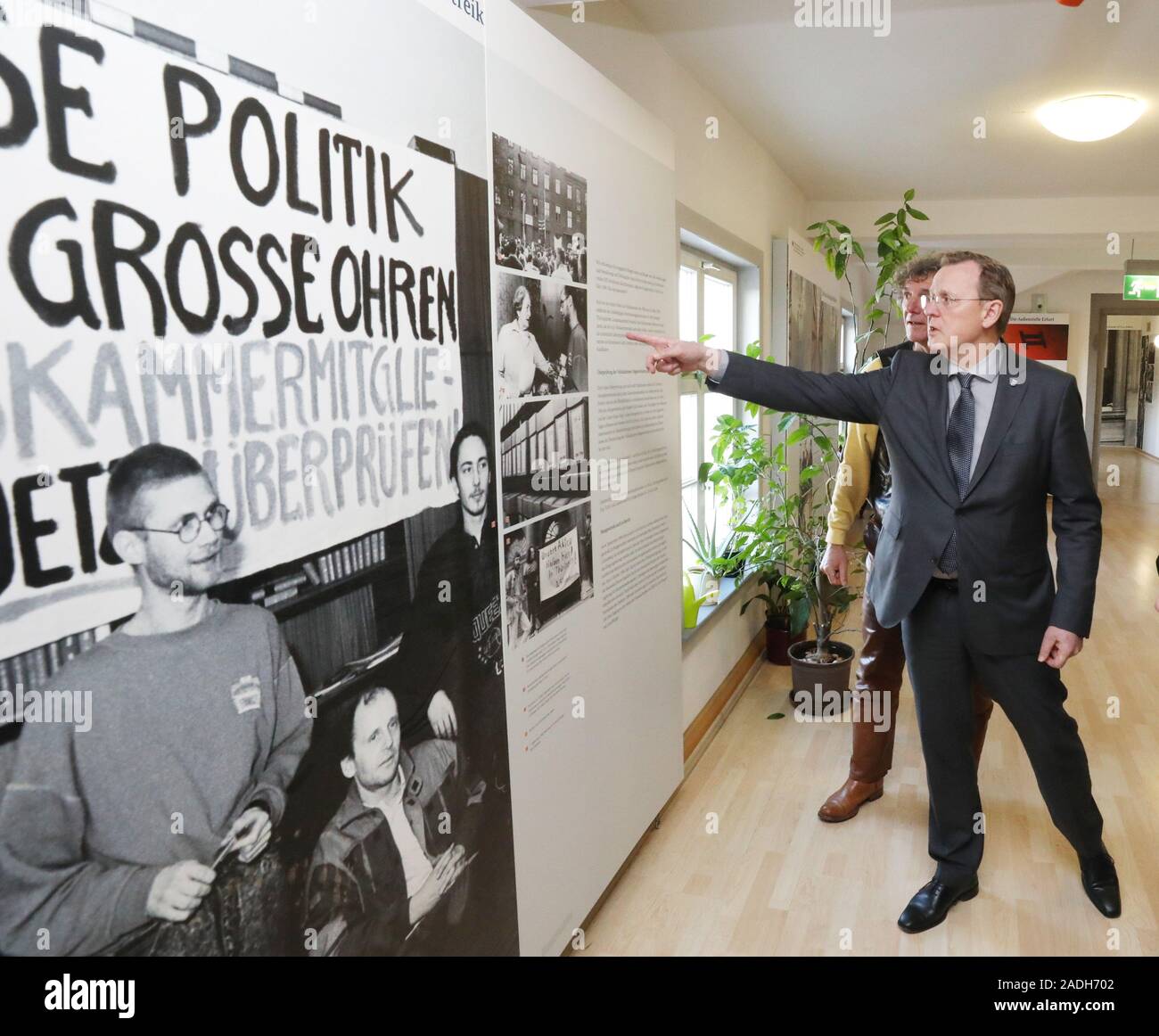 04 December 2019, Thuringia, Erfurt: Bodo Ramelow (Die Linke), Thuringia's Prime Minister, points to a photo of the occupation of the Stasi headquarters on the Petersberg in the branch office of the Stasi Federal Commissioner. Today, 30 years ago, civil rights activists occupied the former district administration of the State Security in Erfurt. Photo: Bodo Schackow/dpa-Zentralbild/dpa Stock Photo