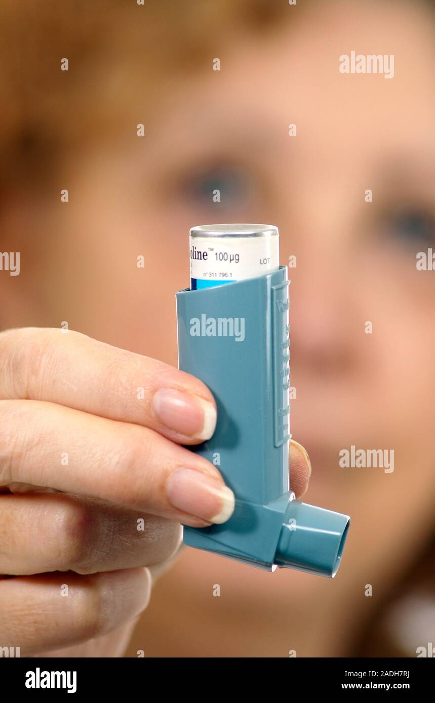 MODEL RELEASED. Asthma inhaler use. Woman holding an asthma inhaler. The inhaler contains