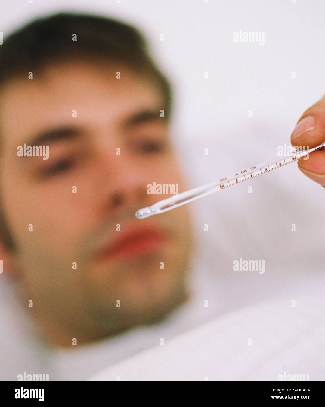 Taking body temperature. Mercury thermometer being used to take the